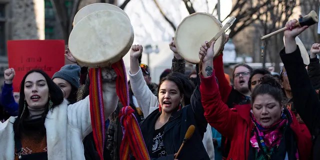 People raise their hands and drums as they rally in solidarity with Wet'suwet'en hereditary chiefs opposed to the Costal GasLink Pipeline, in Ottawa, on Monday, Feb. 24, 2020. (Justin Tang/The Canadian Press via AP)