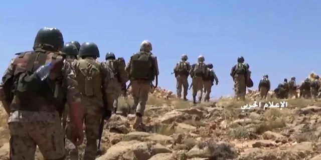 FILE - This file frame grab from video released on July 22, 2017 and provided by the government-controlled Syrian Central Military Media, shows Hezbollah fighters advancing up a hill during clashes with al-Qaida-linked militants in an area on the Lebanon-Syria border. Lebanon's militant Hezbollah group lost at least eight fighters in northwestern Syria in fighting against insurgents and airstrikes by the Turkey's air force following the death of at least 33 Turkish soldiers earlier this week, a Syrian opposition war monitor and the militant group said Saturday. (Syrian Central Military Media, via AP, File)
