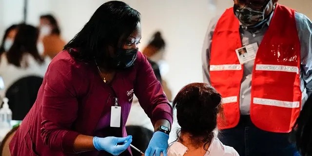 A health worker administers a dose of a Pfizer COVID-19 vaccine during a vaccination clinic at the Grand Yesha Ballroom in Philadelphia. . (AP Photo/Matt Rourke, File)