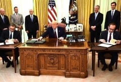 President Trump watches as Kosovar Prime Minister Avdullah Hoti, right, and Serbian President Aleksandar Vucic sign an agreement on normalizing economic relations, in the Oval Office on Friday. (Photo by Brendan Smialowski/AFP via Getty Images)