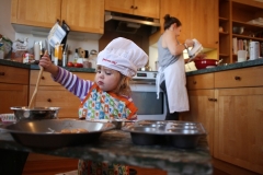 A toddler gets helps mom bake. (Photo by Tim Clayton/Corbis via Getty Images)