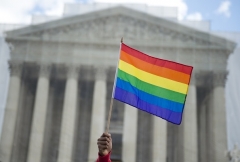 A same-sex marriage supporter waves a rainbow flag in front of the US Supreme Court. (Photo by SAUL LOEB/AFP via Getty Images)