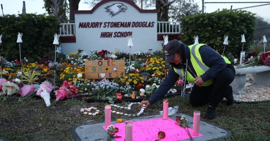 Wendy Behrend, a school crossing guard who was on duty when a shooter opened fire in Marjory Stoneman Douglas High School, pays her respects at a memorial for those killed one year after the shooting on Feb. 14, 2019, in Parkland, Florida.